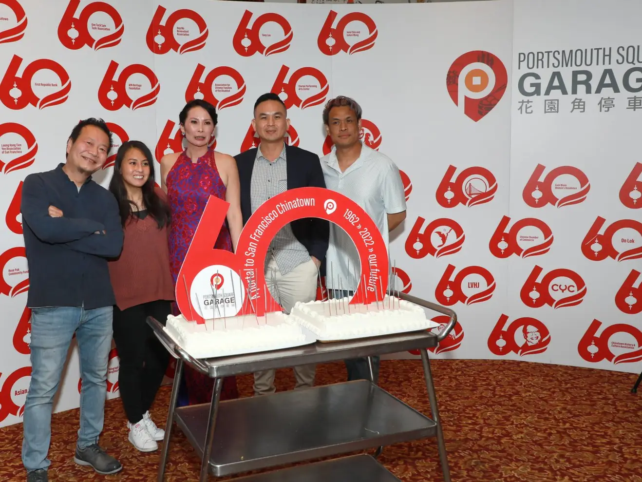 Guests beside the anniversary cake at the 60th Anniversary Gala