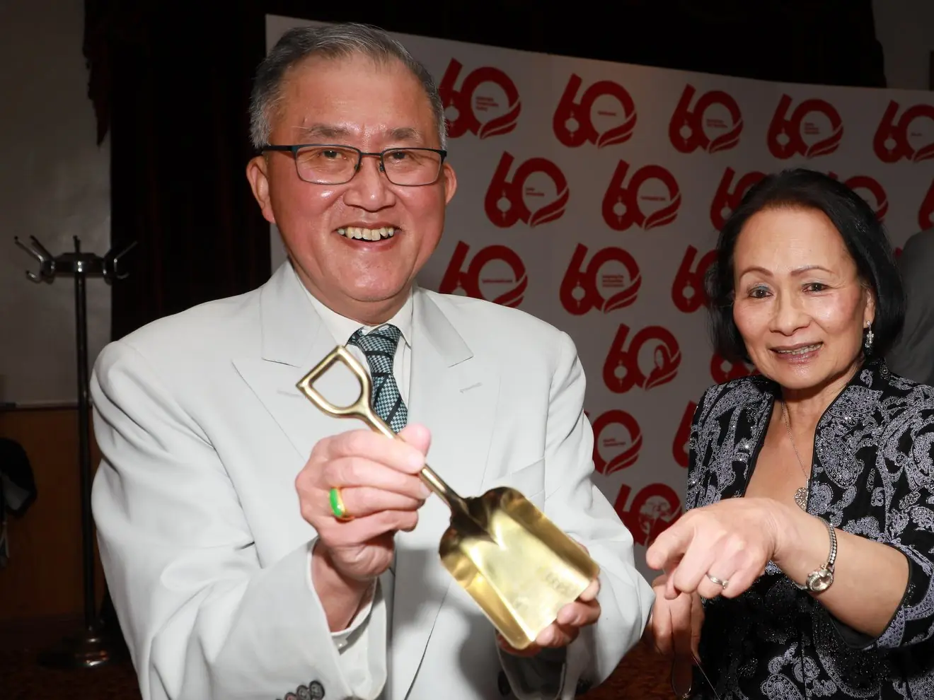 A guest holds the garage's commemorative gold groundbreaking shovel at the 60th Anniversary Gala
