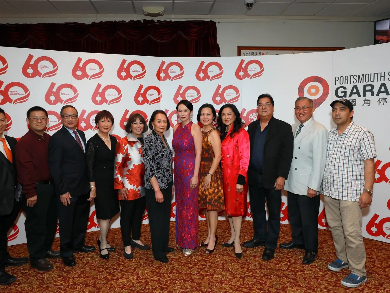 Honorees and guests at the 60th Anniversary Gala, standing together in front of the Portsmouth Square Garage backdrop